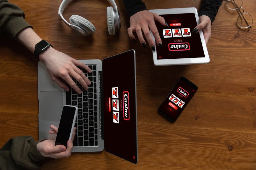 close up laptop and smartphone screen with mobile app for online casino lottery